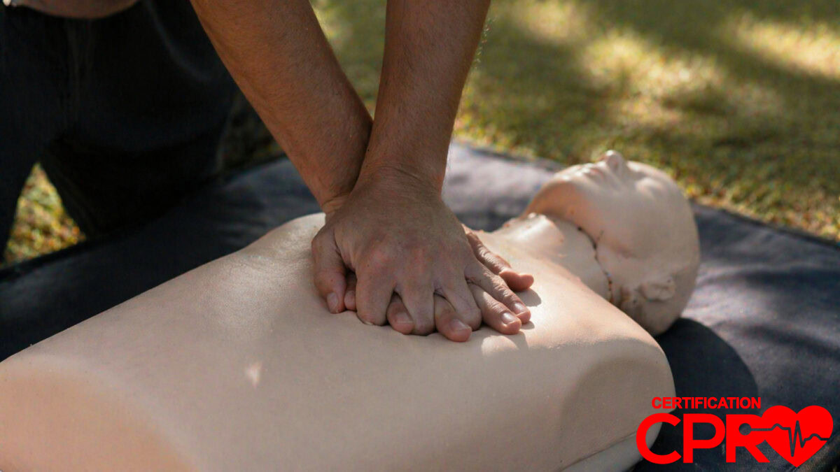 Person performing hands-only CPR on a mannequin outdoors in Chicago.
